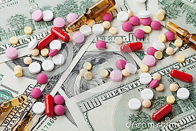 Heap of pharmaceutical drug and medicine pills scattered on dollar cash money, cost medicinal product and treatment concept Stock Photo