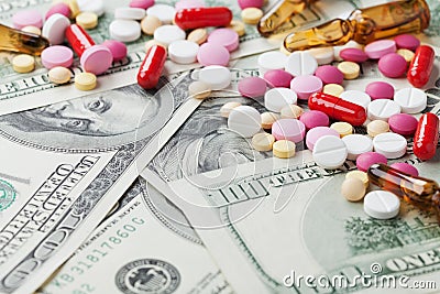 Heap of pharmaceutical drug and medicine pills scattered on dollar cash money, cost medicinal product and treatment concept Stock Photo