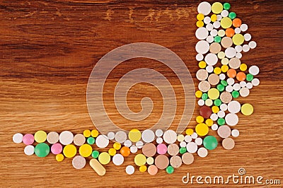 Heap of pills on wooden desk Stock Photo