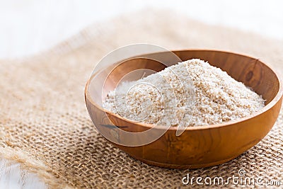 Heap of psyllium husk in wooden bowl on wooden table Stock Photo