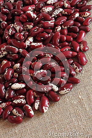 Heap of raw red with white speckled kidney beans on rough linen cloth Stock Photo