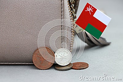 Heap of Rial Omani coin money and mini Oman flag with the leather wallet on grey background Stock Photo