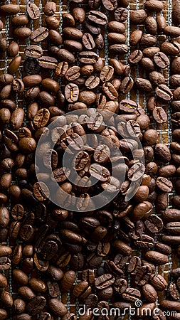 Heap of roasted coffee beans arranged intricately on a matting Stock Photo