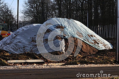 A heap of soil covered with a plastic plane Stock Photo