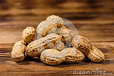 Heap of unpeeled peanuts on rustic wooden table Stock Photo