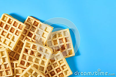 Heap of vanilla belgian waffles on blue background Stock Photo