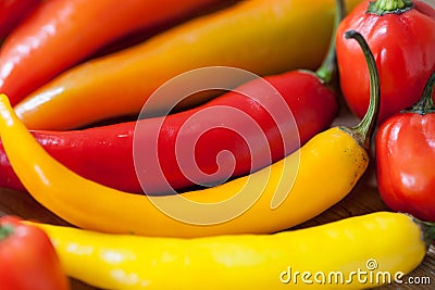 Heap of various chili peppers on a wooden background. Cooking ingredients, spicey taste and organic food concept Stock Photo