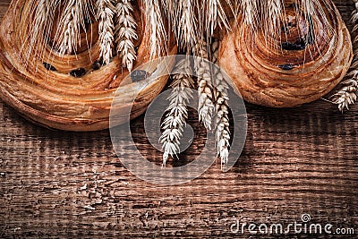 Heap of wheat ears sweet raisin bakery on oaken wooden board foo Stock Photo