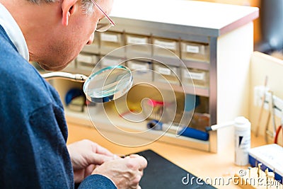 Acoustician working on a hearing aid Stock Photo