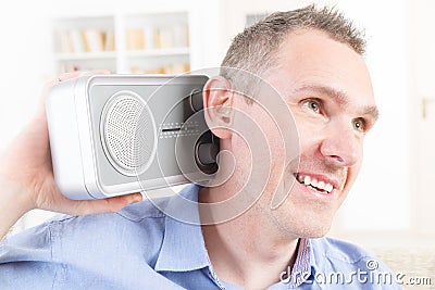 Hearing impaired man trying to listen radio Stock Photo