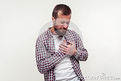 Heart attack, cardiological problems. Portrait of stressed out bearded man grabbing chest suffering acute pain cramp. white Stock Photo