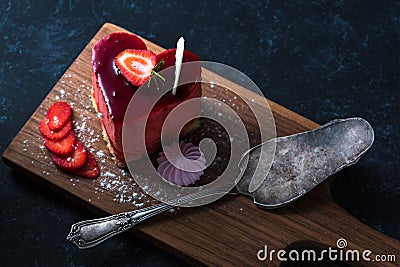 Heart Cake picture . Lovely delicious heart cake. A red colored cheesecake on a plate and a wooden table. Stock Photo