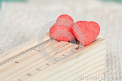 Heart candies coated with sugar sitting on ruler Stock Photo