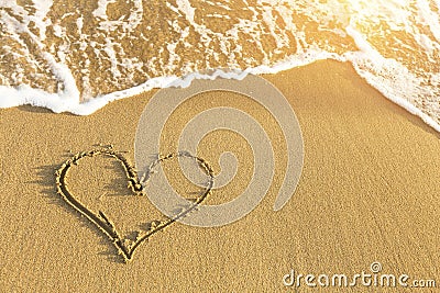 Heart drawn in sea beach sand, soft wave in a Sunny summer day. Love. Stock Photo