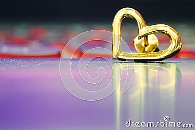 Heart earring on the floor with reflection Stock Photo