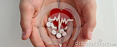 Heart electrocardiogram icon and white pills in children hands Stock Photo