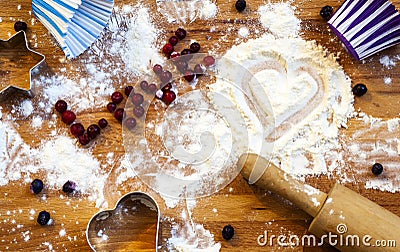 Heart of flour, rolling pin, berries and utensils for baking on wooden background.Happy Valentine`s Day. Love and home Stock Photo
