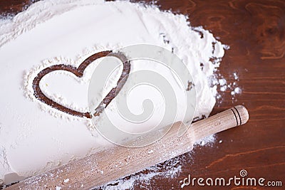 heart on flour and a wooden rolling pin Stock Photo