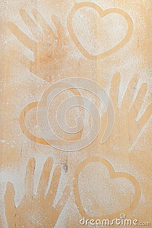 Heart and hand prints and drawing with flour on the board. Stock Photo