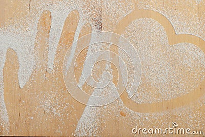 Heart and hand prints and drawing with flour on the board Stock Photo