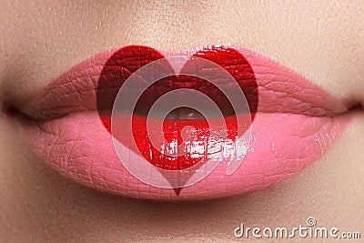 Heart kiss on the Lips. Beauty full lips with heart shape paint. Valentines Day. Beautiful make-up. Lipstick and lipgloss Stock Photo