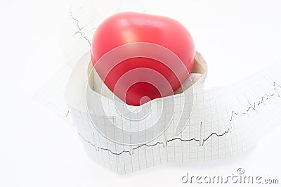 Heart lies on roll tape of electrocardiogram with printed ECG wave. Photo for cardiology, diagnosis and treatment of pathological Stock Photo
