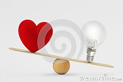 Heart and light bulb on scale - Concept of brain priority over heart in life Stock Photo