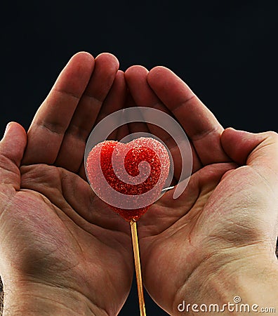 Heart lollipop held in hands Stock Photo