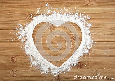 Heart made of flour on a wooden bamboo background Stock Photo