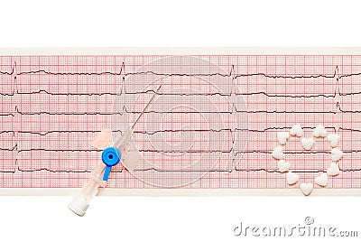 Heart made of white heart shape tablets and blue plastic catheter with open needle on paper ECG results Stock Photo