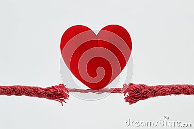 Heart on nearly broken rope - Concept of love and risk Stock Photo