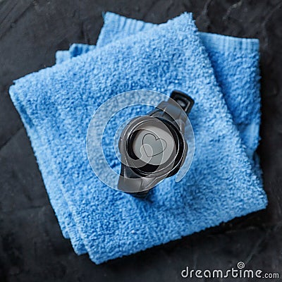 Heart rate monitor on blue towel near soccer ball Stock Photo