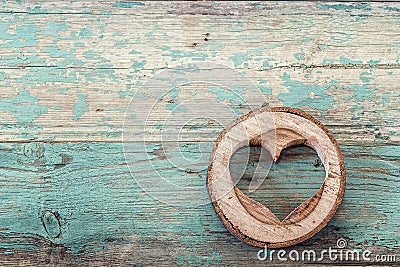 Heart shape carved in wood cut on the old turquoise boards. Stock Photo