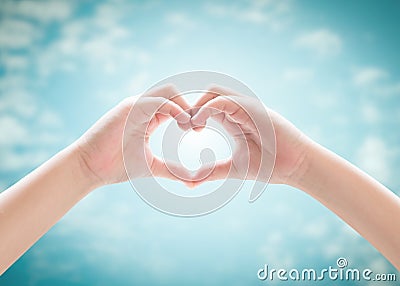 Heart-shape hand gesture of kid`s body language for children`s love, peace, kindness and world humanitarian aid concept. Stock Photo