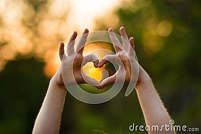 Heart shape hand of kid`s body language for children`s love, kindness, love concept. Heart Hand on nature background Stock Photo