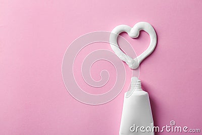 Heart shape made of toothpaste near tube and space for text on color background Stock Photo