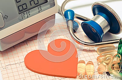 Heart shape, stethoscope, blood pressure monitor and tablets on electrocardiogram. Healthy lifestyles Stock Photo