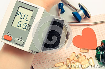 Heart shape, stethoscope, blood pressure monitor and tablets on electrocardiogram. Healthy lifestyles Stock Photo