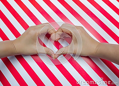 Heart shape of two hand put on striped pattern red & white placemats Stock Photo