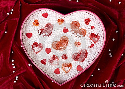 Heart-shaped box filled with small foam balls and handmade paper hearts Stock Photo