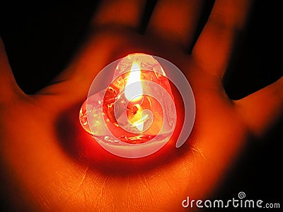 Heart shaped burning red candle in the palm of the hand in the dark. Valentine`s day concept. Unshared love concept Stock Photo