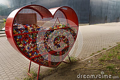 Heart-Shaped Container Collecting Plastic Plugs for Recycling in Urban Park Stock Photo