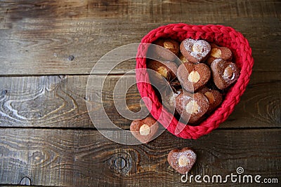 Heart-shaped cookies in a red heart-shaped basket on a wooden background with copy space for text Stock Photo