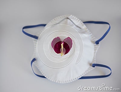 A heart-shaped petal on a medical mask Stock Photo