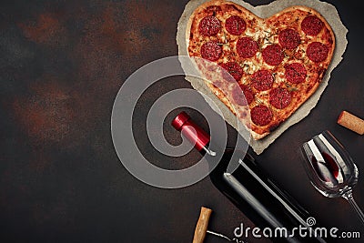 Heart shaped pizza with mozzarella, sausagered with a bottle of wine and wineglas on rusty background Stock Photo