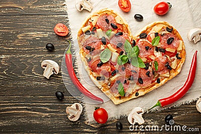 Heart-shaped pizza, Valentine`s Day. With vegetables. A concept of tasty and healthy food with love. Free-lay Stock Photo