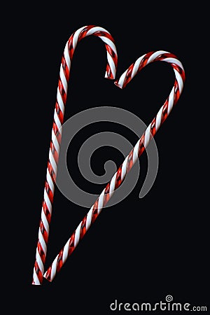 Heart shaped red and white traditional Christmas candy cane on black background greeting card motive Stock Photo