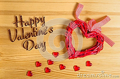 Heart sign Happy Valentine`s Day on a wooden texture, and small glass hearts Stock Photo