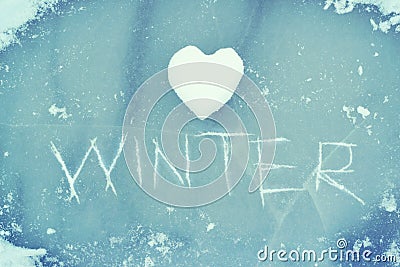 Heart from snow and the word WINTER scratched on ice. Winter theme. Stock Photo
