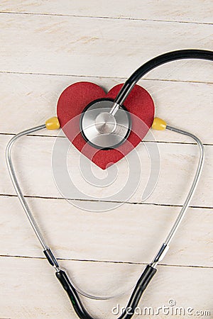 Heart with stethoscope on white wooden table. Medical concept. Top views with clear space Stock Photo